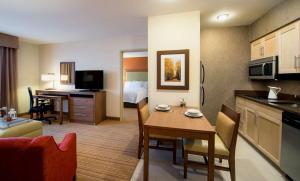 a hotel room with a kitchen and a dining room at Homewood Suites by Hilton Winnipeg Airport - Polo Park in Winnipeg