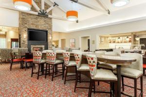 a restaurant with a long table and chairs and a fireplace at Homewood Suites by Hilton Long Island-Melville in Plainview