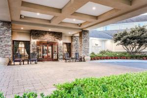 un grand patio avec des chaises et un bâtiment dans l'établissement Homewood Suites by Hilton Long Island-Melville, à Plainview