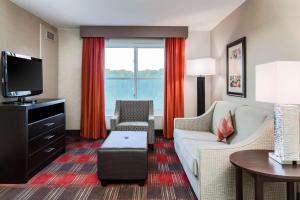 sala de estar con sofá y TV en Homewood Suites by Hilton Long Island-Melville, en Plainview