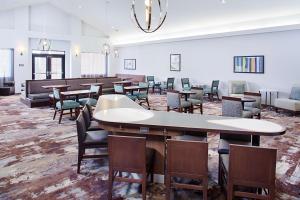 a dining room with tables and chairs and a large room at Homewood Suites Lancaster in Lancaster