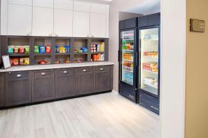 uma cozinha com armários de madeira escura e um frigorífico aberto em Homewood Suites Lancaster em Lancaster
