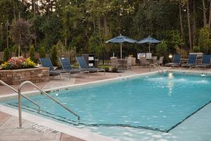 a large swimming pool with chairs and umbrellas at Hampton Inn & Suites by Hilton Augusta-Washington Rd in Augusta