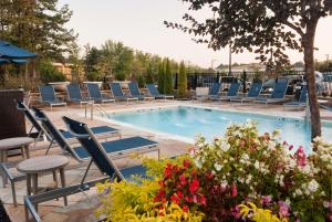 a swimming pool with lounge chairs and flowers at Hampton Inn & Suites by Hilton Augusta-Washington Rd in Augusta