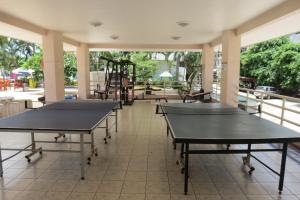 two ping pong tables in a room with windows at View Talay 1B Residence in Pattaya South