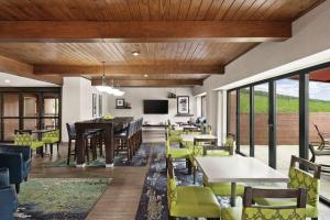 een eetkamer met tafels, stoelen en ramen bij Hampton Inn Atlanta-Stone Mountain in Stone Mountain