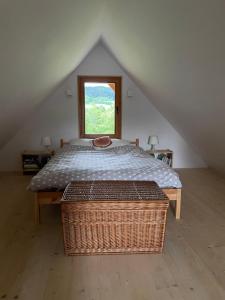 um quarto com uma cama e uma janela num sótão em Woźniówka pod Mogielicą em Słopnice