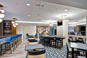 Homewood Suites by Hilton Boston Brookline-Longwood Medical في بروكلاين: مطعم بطاولات وكراسي وبار