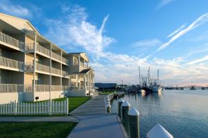 un gran edificio de apartamentos junto a una masa de agua en Hampton Inn & Suites Chincoteague-Waterfront, Va, en Chincoteague