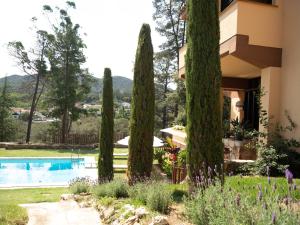 una casa con árboles frente a una piscina en Les Alzines - Chalet con gran piscina cerca de Barcelona, en Òrrius