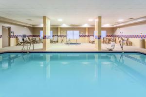 - une piscine dans une chambre d'hôtel avec des chaises et des tables dans l'établissement Hampton Inn & Suites Chicago - Libertyville, à Libertyville