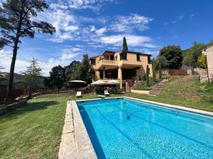 ein Haus mit einem Swimmingpool vor dem Haus in der Unterkunft Les Alzines - Chalet con gran piscina cerca de Barcelona in Orrius
