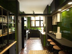 una cocina con paredes y taburetes de azulejos verdes en Les Alzines - Chalet con gran piscina cerca de Barcelona, en Òrrius