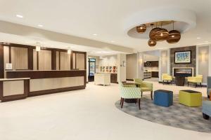 a lobby with a waiting area with chairs and tables at Homewood Suites by Hilton Frederick in Frederick