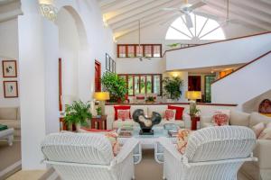 a living room with white furniture and a ceiling fan at Sunny Vacation Villa No 93 in San Rafael del Yuma