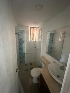 uma casa de banho com um WC, um lavatório e um espelho. em Hermoso y lujoso apartamento en Bello em Bello