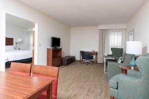 um quarto de hotel com uma cama e uma sala de estar em Hampton Inn Grand Rapids/North em Grand Rapids