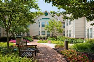 a bench on a brick walkway in front of a house at Homewood Suites Harrisburg-West Hershey Area in Mechanicsburg