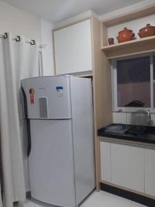 uma cozinha com um frigorífico branco em Aconchego Lagoinha Casa Frente em Florianópolis