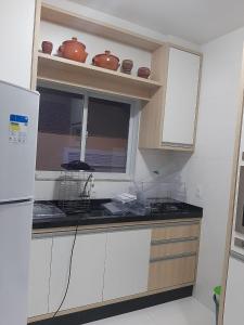 una cocina con encimera y una ventana con ollas en Aconchego Lagoinha Casa Frente, en Florianópolis