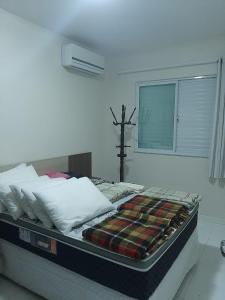 Una cama con una manta en un dormitorio en Aconchego Lagoinha Casa Frente, en Florianópolis