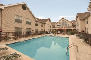 a swimming pool with tables and chairs and a building at Homewood Suites Harrisburg-West Hershey Area in Mechanicsburg