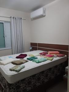 uma cama grande com almofadas num quarto em Aconchego Lagoinha Casa Frente em Florianópolis
