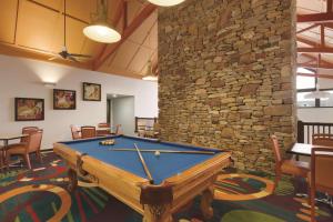 Homewood Suites Harrisburg-West Hershey Area في ميتشانيكسبورغ: طاولة بلياردو في غرفة مع جدار حجري