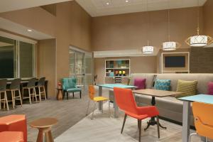 a waiting room with colorful chairs and tables at Home2 Suites By Hilton Chantilly Dulles Airport in Chantilly