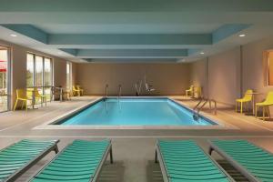 a pool in a hotel room with chairs at Home2 Suites By Hilton Chantilly Dulles Airport in Chantilly