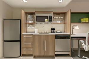 a kitchen with a refrigerator and a sink at Home2 Suites By Hilton Chantilly Dulles Airport in Chantilly