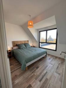- une chambre avec un lit et une grande fenêtre dans l'établissement Maison de vacances à 200 m de l'Aber Benoît, à Landéda