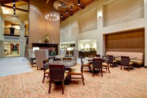 a restaurant with tables and chairs and a fireplace at Homewood Suites Houston Kingwood Parc Airport Area in Kingwood