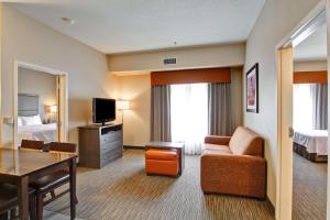 a hotel room with a bed and a living room at Homewood Suites Houston Kingwood Parc Airport Area in Kingwood