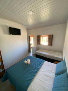 1 dormitorio con 1 cama y 2 toallas blancas en suítes Pataxós, en Cumuruxatiba