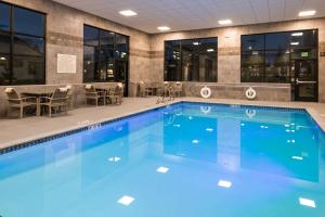 einen Pool mit Stühlen und Tischen in einem Gebäude in der Unterkunft Hampton Inn & Suites Olympia Lacey, Wa in Olympia