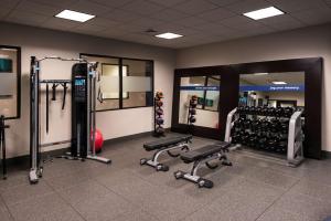 einen Fitnessraum mit mehreren Laufbändern und Maschinen in einem Zimmer in der Unterkunft Hampton Inn & Suites Olympia Lacey, Wa in Olympia