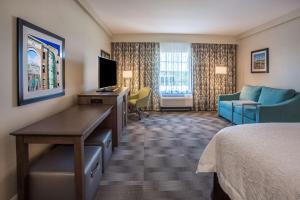 Habitación de hotel con cama, escritorio y TV. en Hampton Inn & Suites Yonkers - Westchester en Yonkers