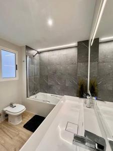 Un baño blanco con bañera y inodoro. en Casa amplia y moderna de 5 habitaciones hasta 12 personas, en Puerto Sagunto