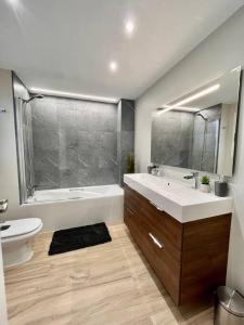 Un baño con bañera, lavabo e inodoro. en Casa amplia y moderna de 5 habitaciones hasta 12 personas, en Puerto Sagunto 16 fotos más