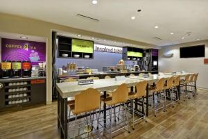 a restaurant with a bar with chairs and a counter at Home2 Suites by Hilton Little Rock West in Little Rock