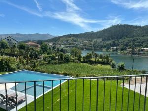 a balcony with a pool and a view of a river at Ermal Terrace in Vieira do Minho