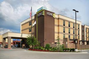 马斯科吉Home2 Suites By Hilton Muskogee的一座酒店大楼前悬挂着一面美国国旗