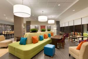 a lobby with a green couch with colorful pillows at Home2 Suites By Hilton La Crosse in La Crosse