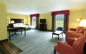 Mill HallにあるHampton Inn and Suites of Lamarのベッド、デスク、椅子が備わるホテルルームです。