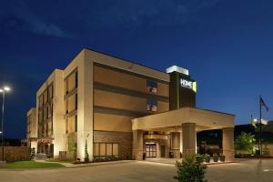 a hotel building with a sign on top of it at Home2 Suites By Hilton Muskogee in Muskogee