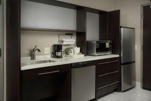 a kitchen with a sink and a microwave at Home2 Suites By Hilton Muskogee in Muskogee