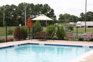 - une piscine avec des chaises et un parasol dans l'établissement Hampton Inn & Suites Exmore - Eastern Shore, à Exmore
