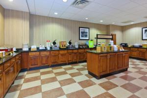 a kitchen with wooden cabinets and a checkerboard floor at Hampton Inn & Suites Exmore - Eastern Shore in Exmore