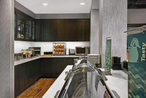 cocina con armarios de madera y encimera en Homewood Suites - Doylestown, en Warrington